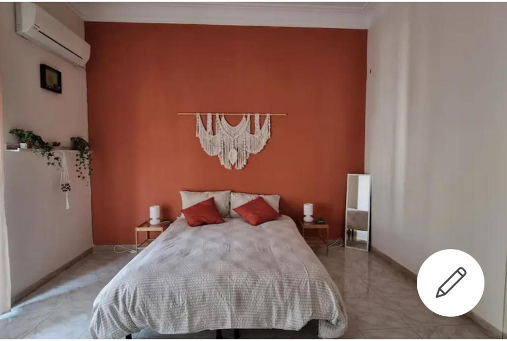 una camera da letto con un letto grande con pareti arancioni di Etna Ocean Rooms a Catania