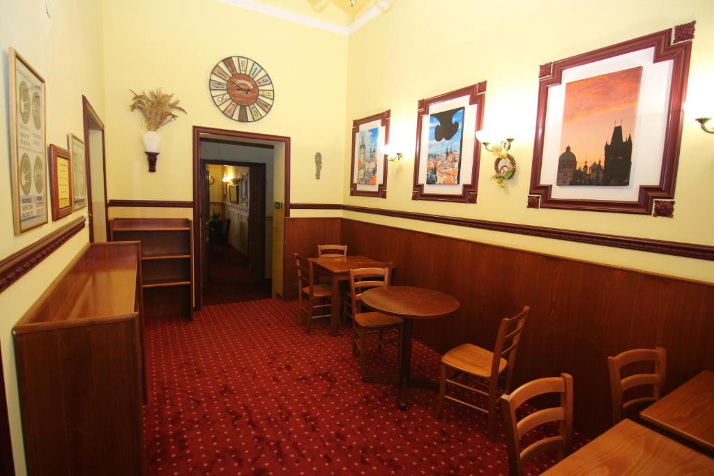 a restaurant with tables and chairs and a clock on the wall at Old Prague Hotel in Prague
