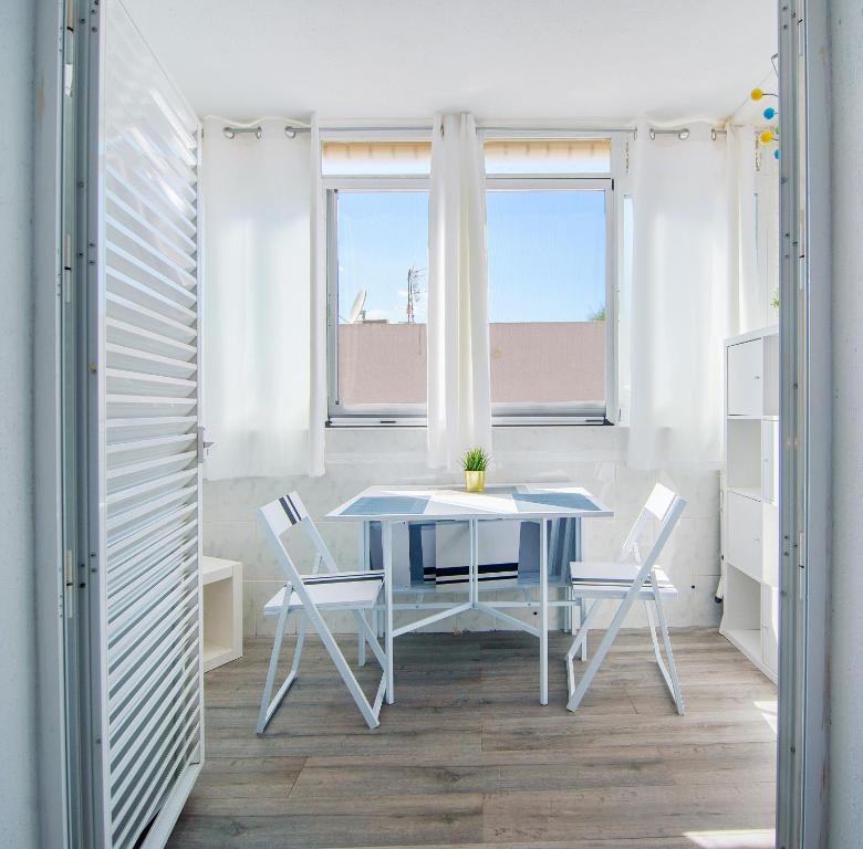 mesa y sillas en una habitación con ventana en NATURA MEDITERRANEA primera linea con piscina, en Vera