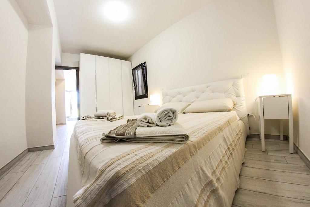 a white bedroom with a large bed with towels on it at Casavacanze Natoli in Castel di Tusa