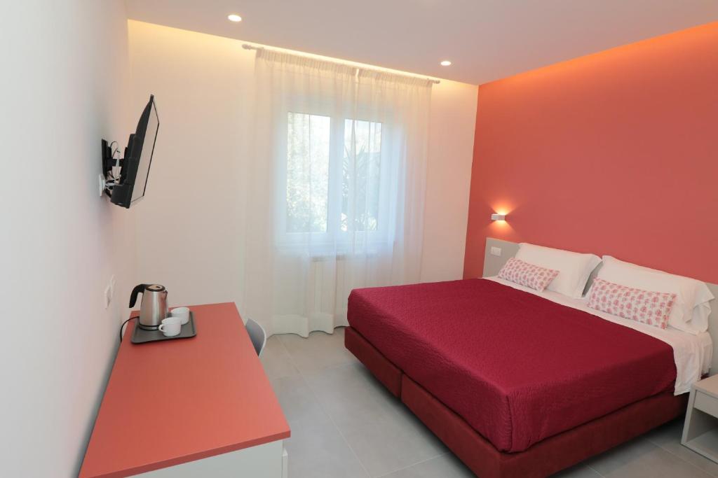 um quarto com uma cama vermelha e uma mesa vermelha em Maison Nanà em Sorrento