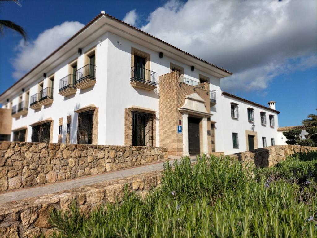 une maison blanche avec un mur en pierre dans l'établissement Hacienda Atalaya, à La Rambla