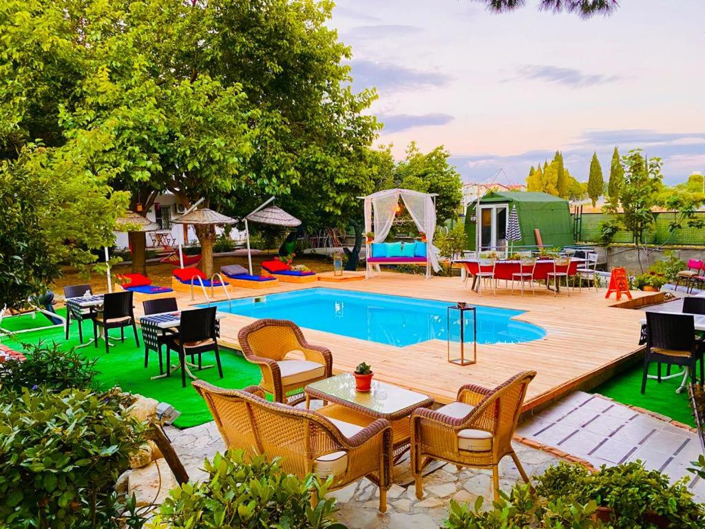 una piscina con sillas y una mesa junto a una terraza en Mursel Garden Hotel, en Kusadasi