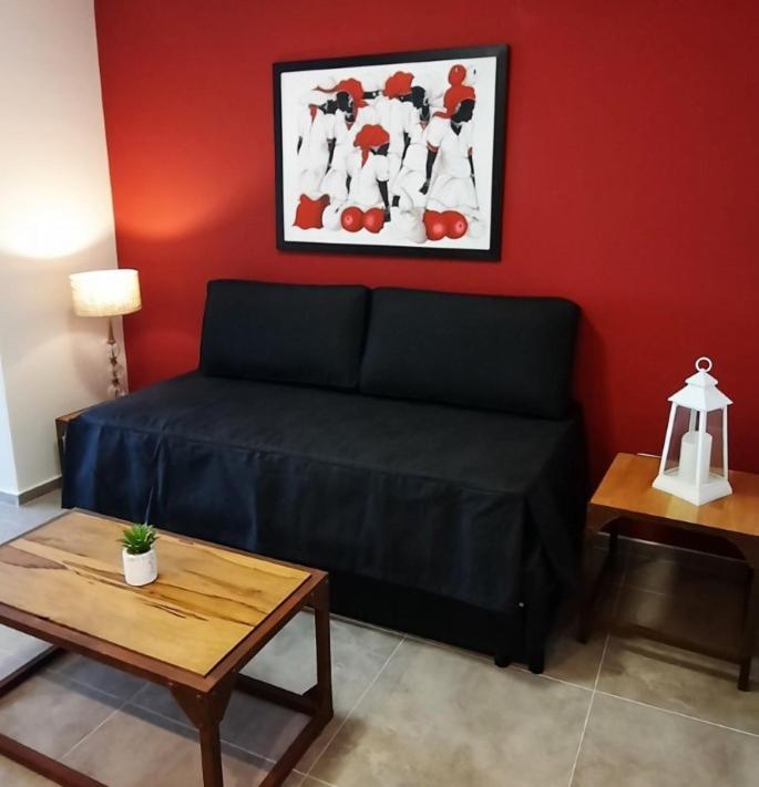 a living room with a black couch and a table at Departamento Calchines con cochera in Santa Fe