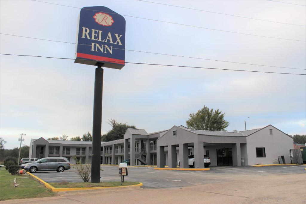 un bâtiment avec un panneau d'auberge raka dans un parking dans l'établissement Relax Inn Canton, à Canton