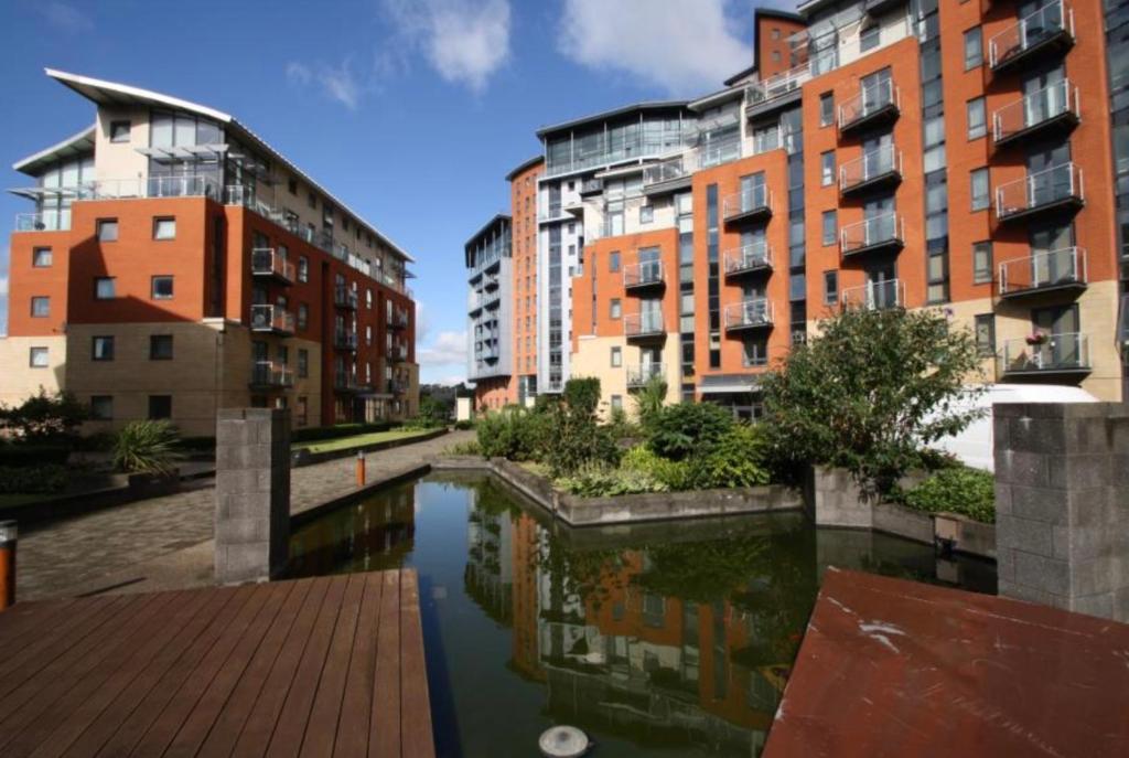 a group of buildings and a river with buildings at Entire Studio in picturesque City Islands - Short Walk from Leeds Centre in Leeds