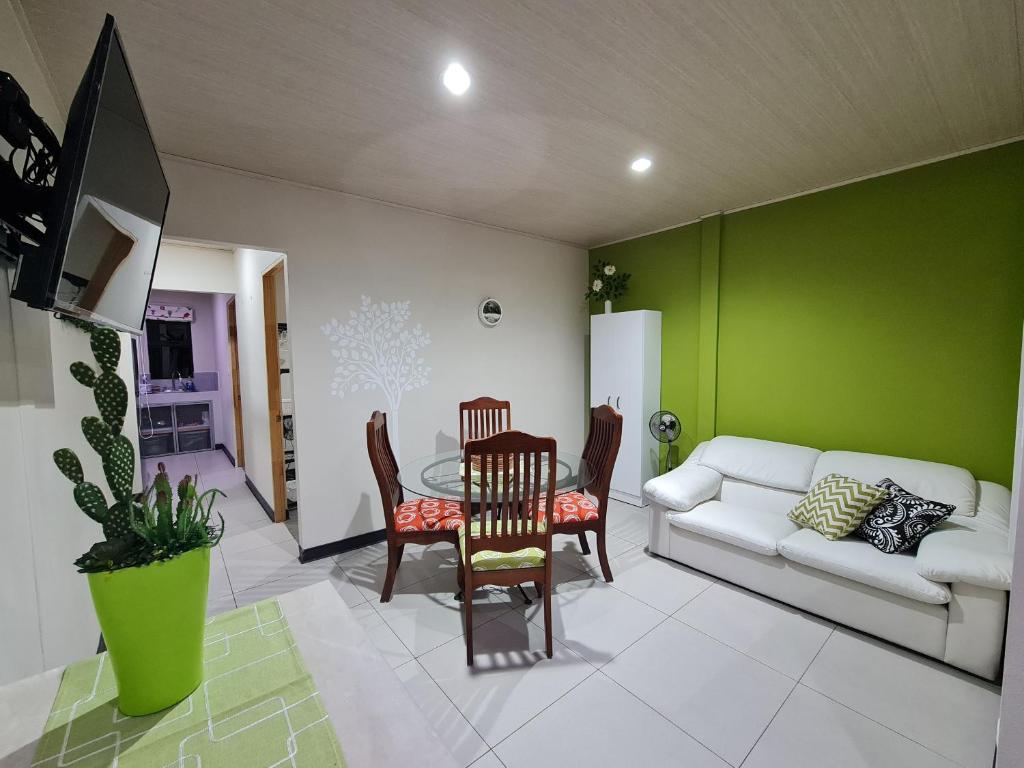 - un salon avec une table, des chaises et un canapé dans l'établissement Fully-equipped 2-bedroom apartment in San José, à San José