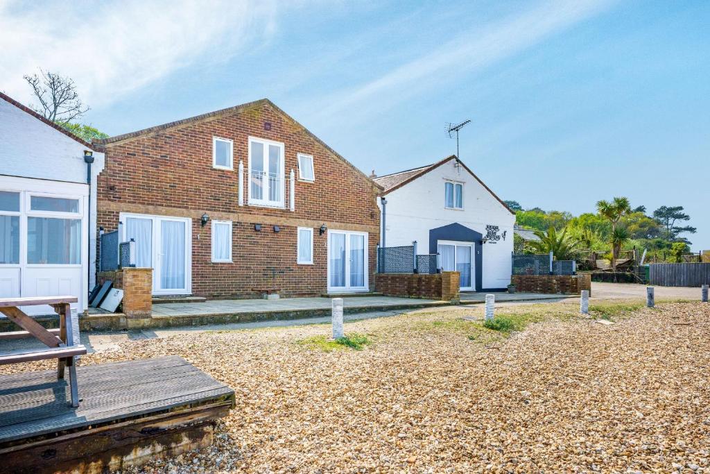 a brick house with white doors on a beach at Starboard in Yarmouth