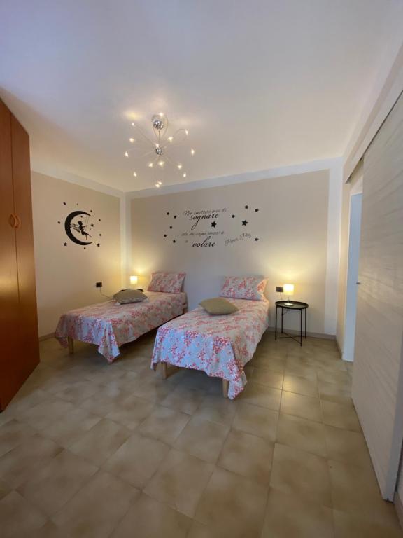 un dormitorio con 2 camas y una pared con escritura. en Intero alloggio :Casa D D Nuova aperturaHost Rosi en Omegna