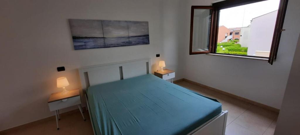a bedroom with a blue bed and two tables with lamps at La casetta di Daniela in Policoro