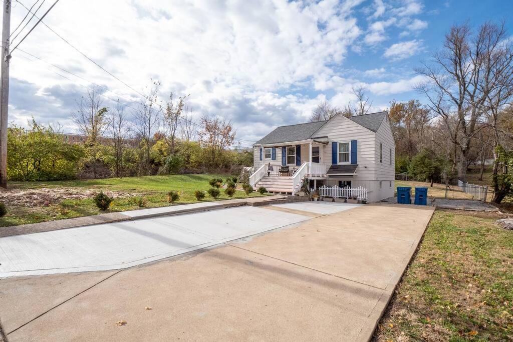 a white house with a porch and a driveway at Cozy house to call home away from home in Maryland Heights