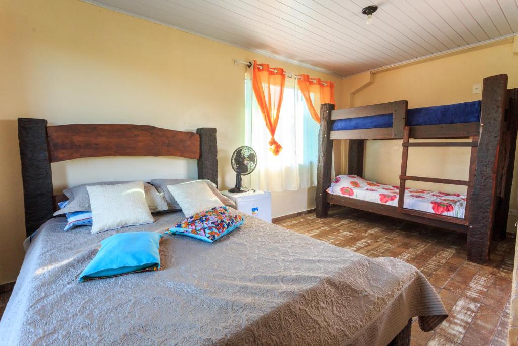 a bedroom with a bed and two bunk beds at Cachoeira do Alemão - Recanto dos Arcos in Balsa Nova