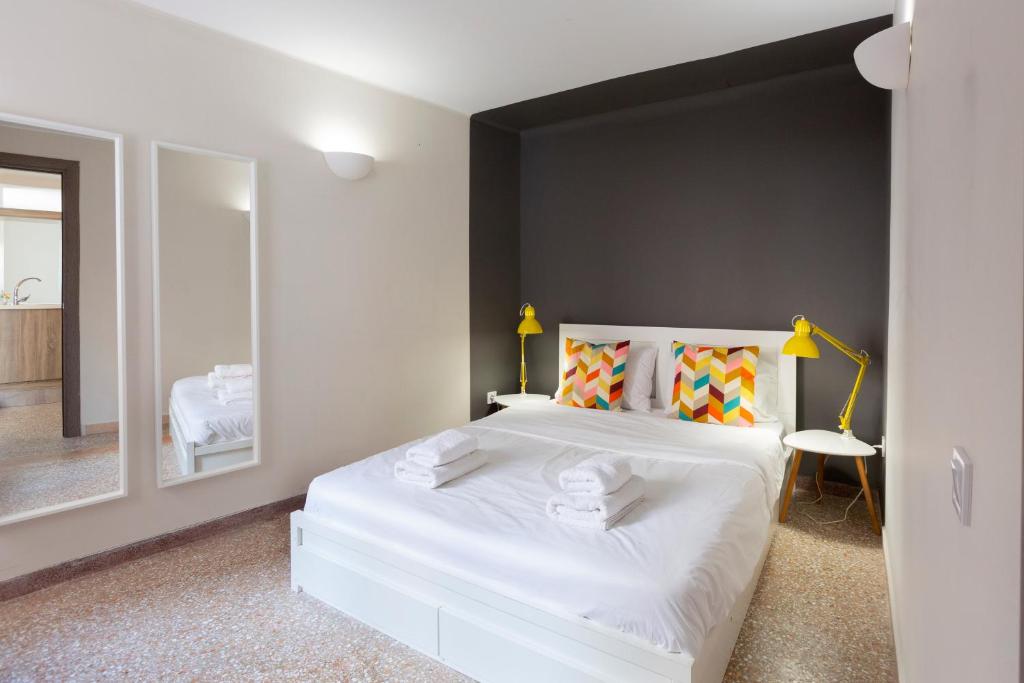 a bedroom with a large white bed and a mirror at Psirri Place economy apartments centrally located in Athens