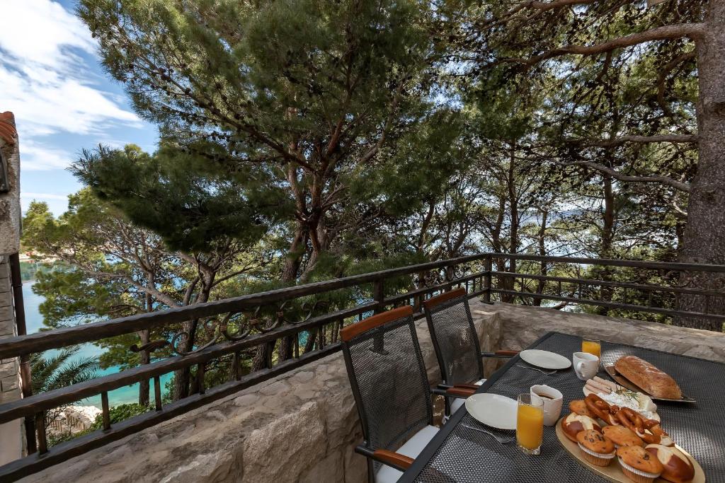 a table with a plate of food on a balcony at Villa AMore Brela in Brela