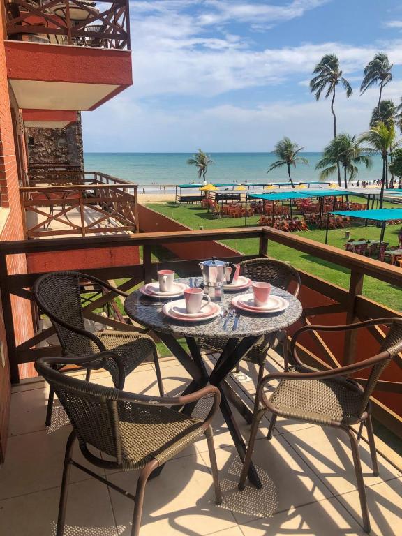 a table and chairs on a balcony with a view of the beach at Kariri Beach - 207 - Praia do Cumbuco, Caucaia in Cumbuco