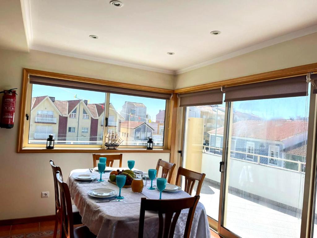 comedor con mesa y ventana grande en Xavega Apartment en Torreira