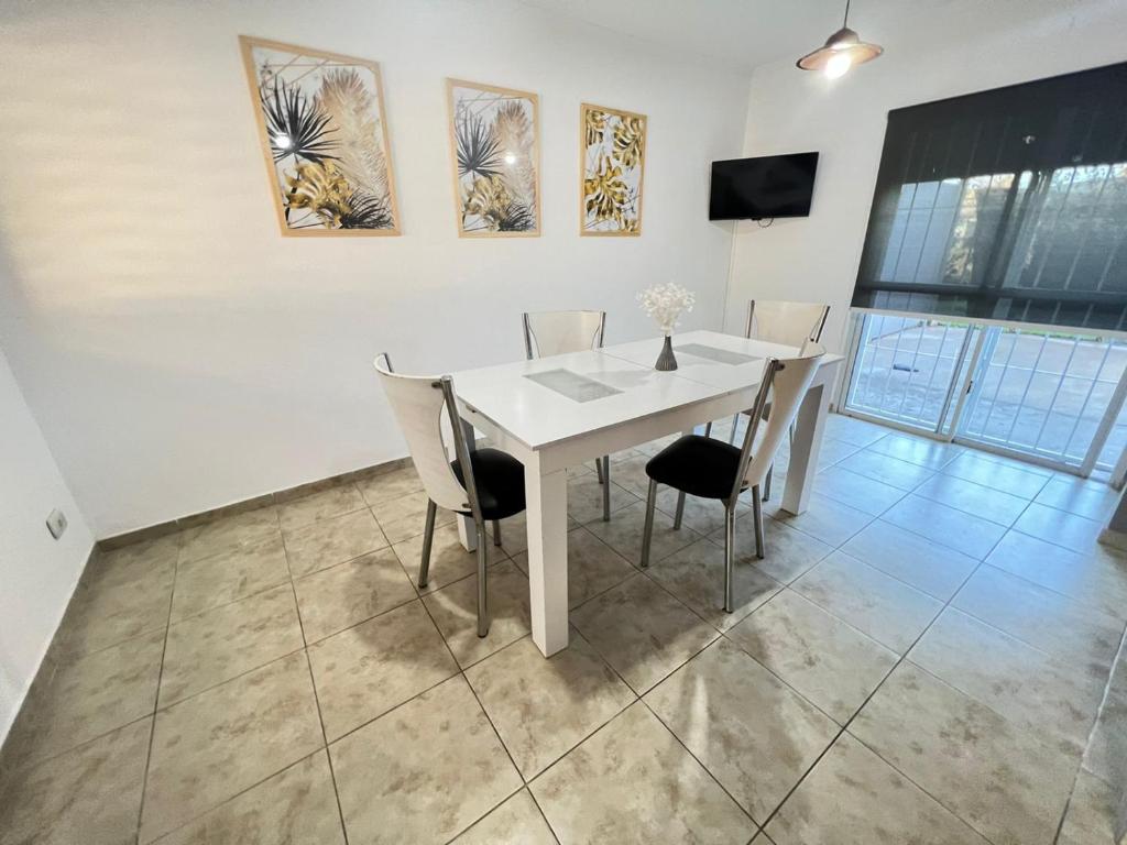 a dining room with a white table and chairs at Bv colon 351 Apart Firmat 2 in Firmat