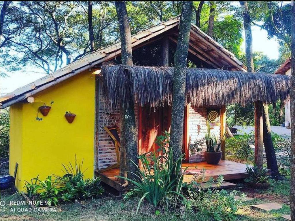 uma pequena casa amarela com telhado de palha em Chalé Rústico - Retiro Andaluz em Moeda