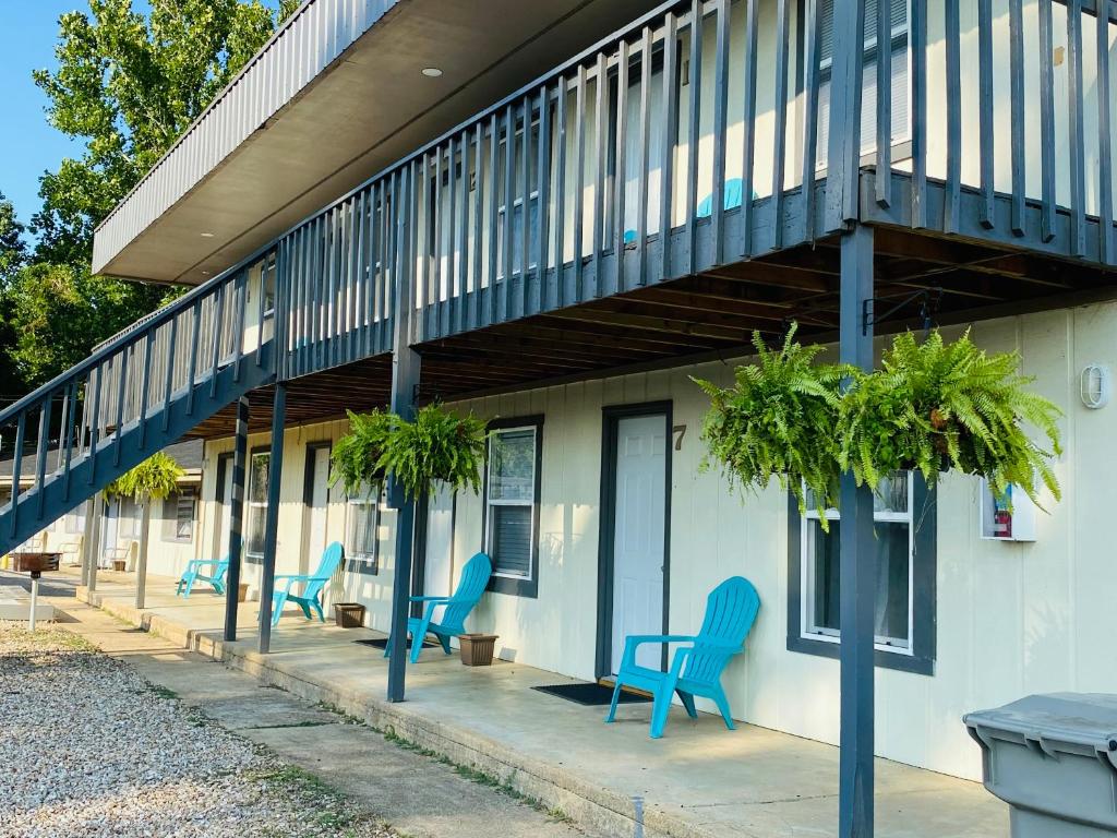 grupa niebieskich krzeseł siedzących przed budynkiem w obiekcie Rockwood Resort Motel w mieście Lake Ozark