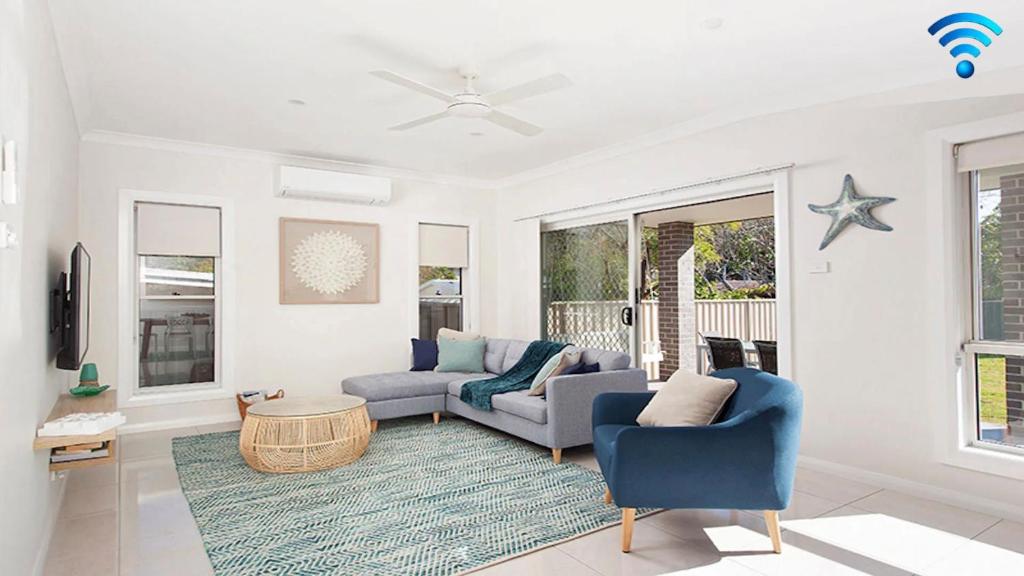 a living room with a couch and a table at Calm at Shoal Bay in Shoal Bay