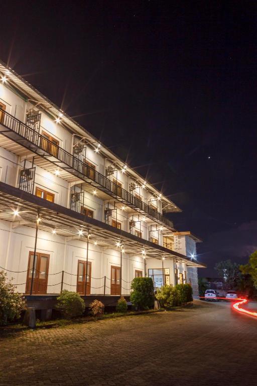 Un gran edificio blanco con luces por la noche. en Wisma Amandari, en Bandar Lampung