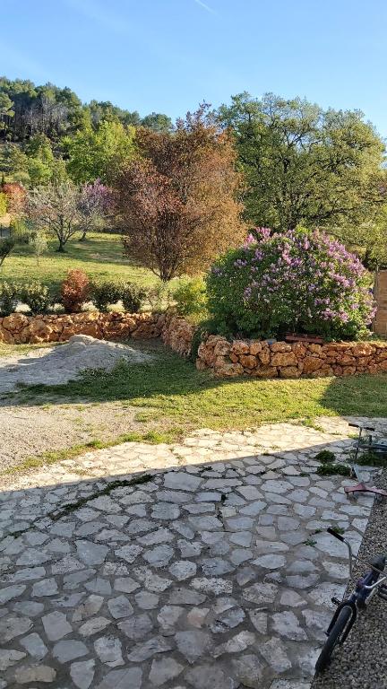 une passerelle en pierre avec un banc dans un parc dans l'établissement Maison de campagne, à Flayosc