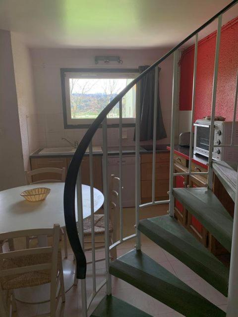 a staircase leading to a room with a table and a window at Le Piroulet in Vassieux-en-Vercors