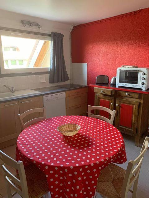 a kitchen with a table with a polka dot table cloth at Le Piroulet in Vassieux-en-Vercors