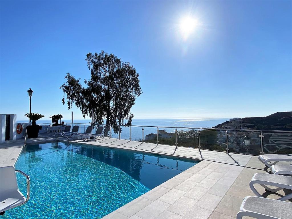 - une piscine avec des chaises et l'océan en arrière-plan dans l'établissement Balcon del Mar Seaview 216 Casasol, à Nerja