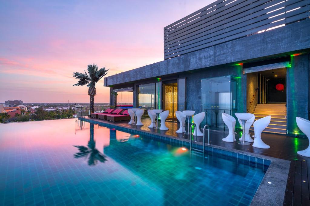 a swimming pool with chairs and a building at Regal Réseau Hotel & Spa in Negombo