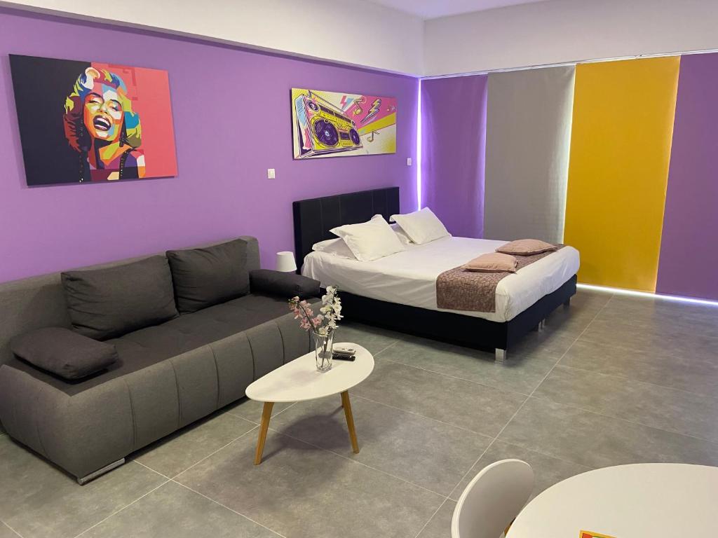 a room with a bed and a couch and a bed and a table at Connect Suites in Athens