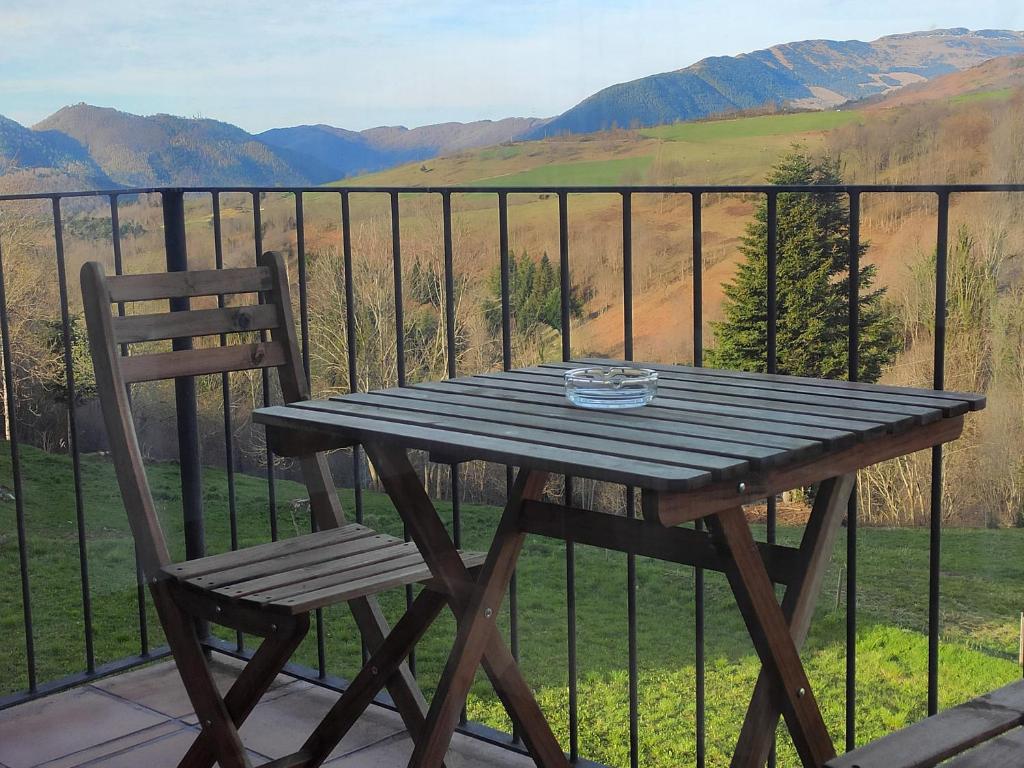 una mesa de picnic de madera y una silla en el balcón en Allotjaments Paratge Fabas en Molló