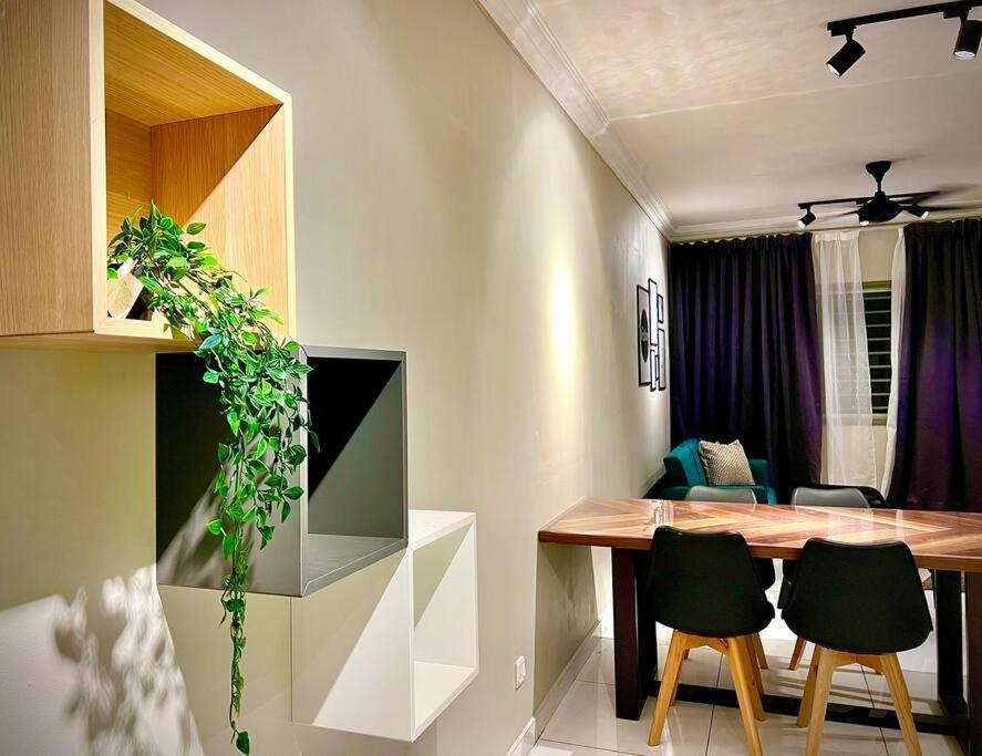 cocina y comedor con mesa y sillas en Semenyih 3 Bedroom Apartment by Miraaz, en Beranang