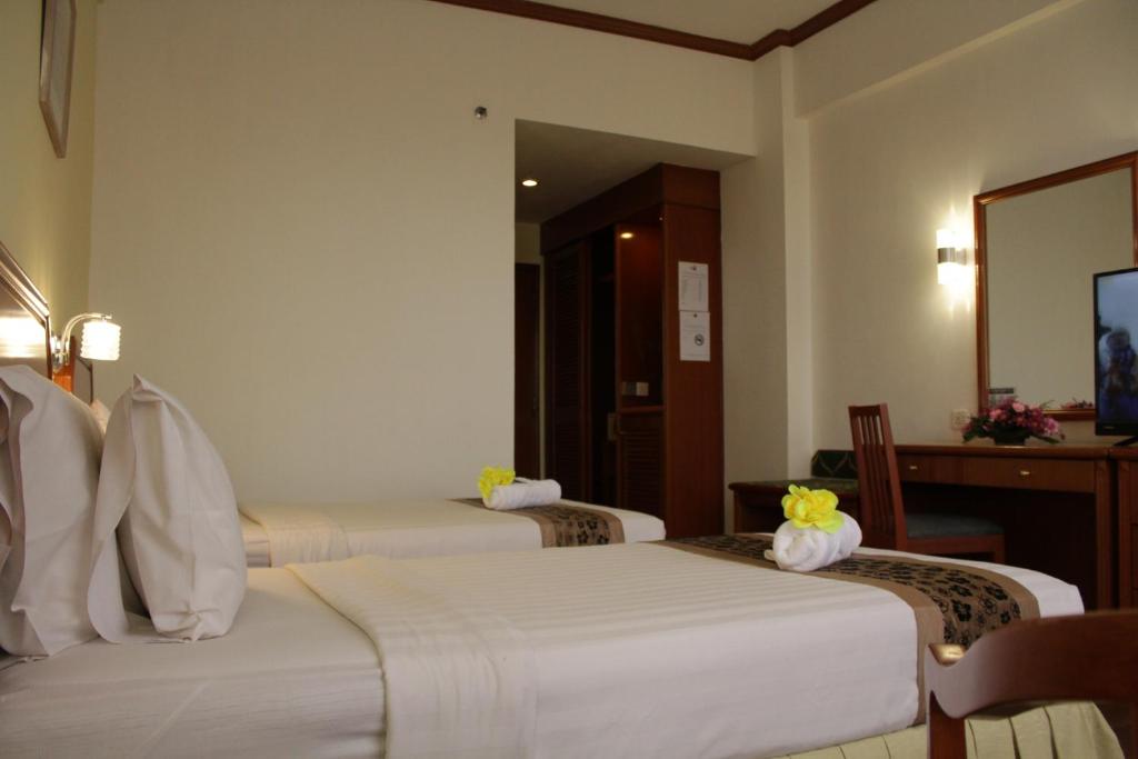 Postel nebo postele na pokoji v ubytování Hotel Sandakan