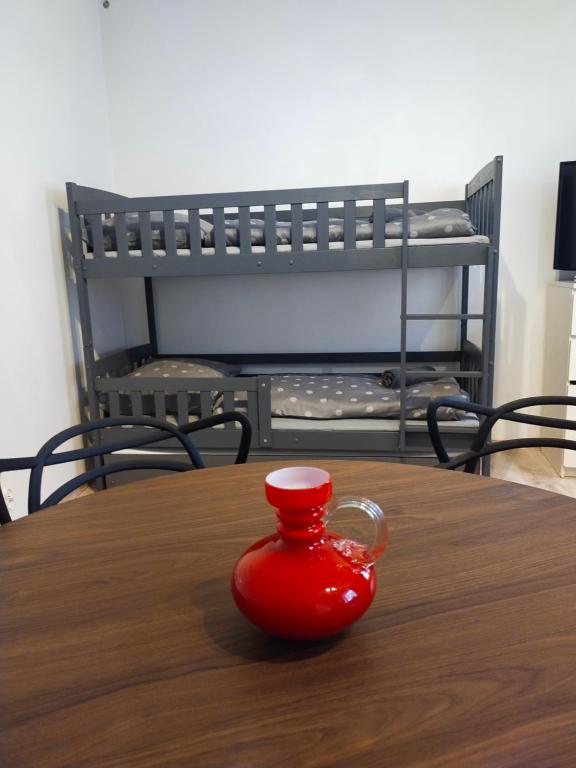 a red cup sitting on top of a wooden table at Apartament Przy rynku in Duszniki Zdrój