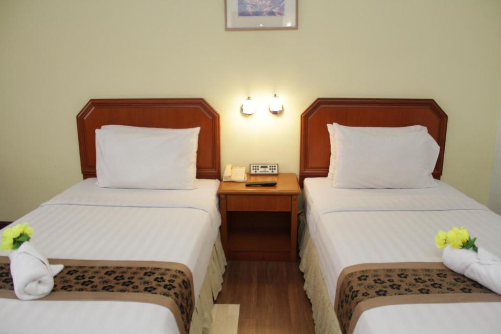 Postel nebo postele na pokoji v ubytování Hotel Sandakan