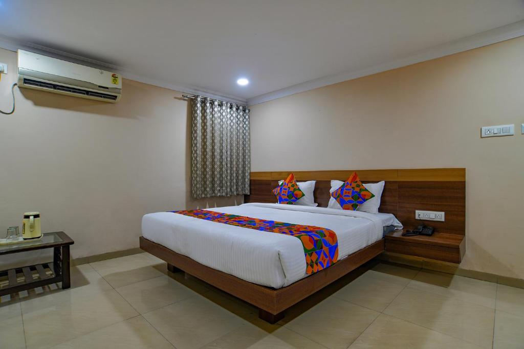 1 dormitorio con 1 cama grande en una habitación en FabHotel Pishori en Indore