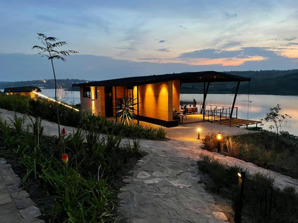 een huis met uitzicht op het water bij zonsondergang bij UMVA Muhazi in Muhazi