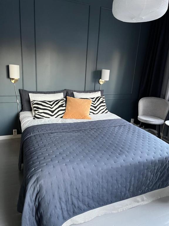 um quarto azul com uma cama grande com almofadas em The Bird Cherry Junior Suite em Varkaus