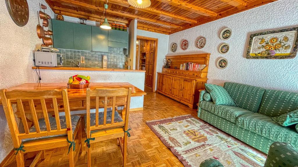 a living room with a green couch and a table at Eugenia - Maison dOc in Bardonecchia