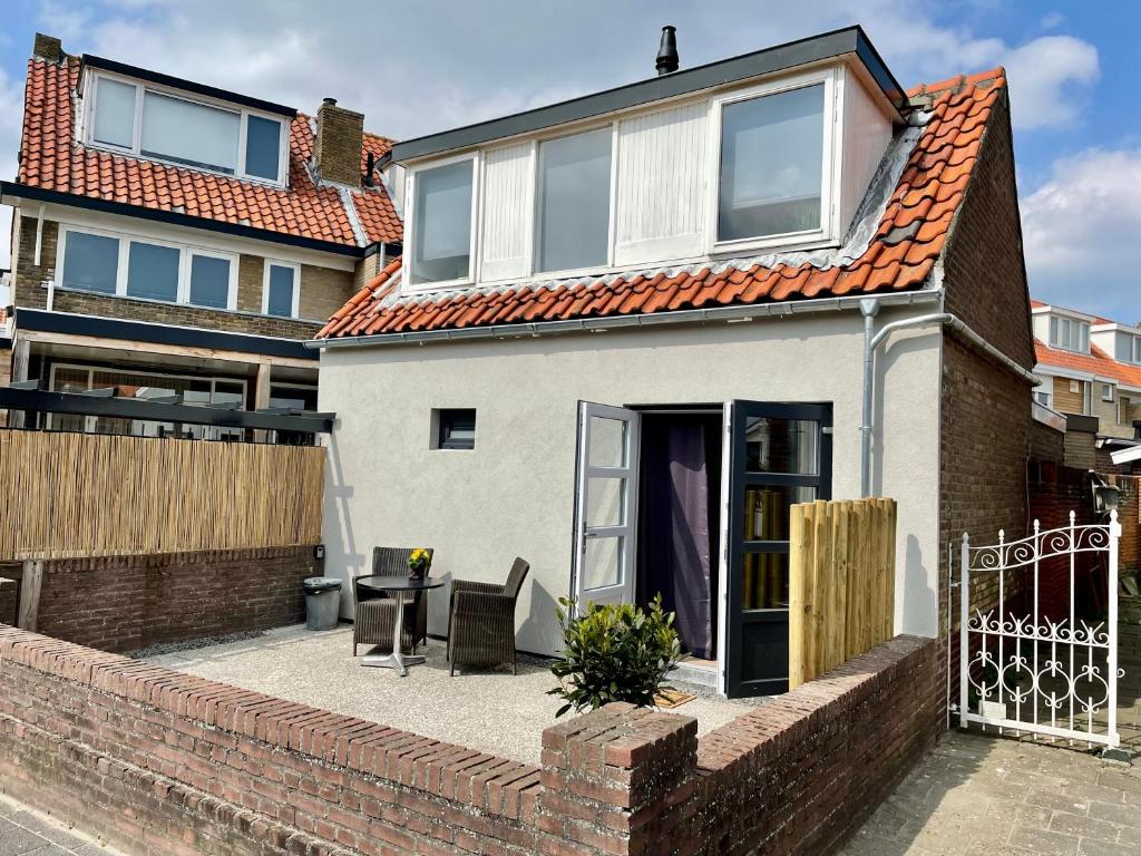 una casa blanca con techo naranja en T-Rots, prachtig zomerhuis en Noordwijk aan Zee