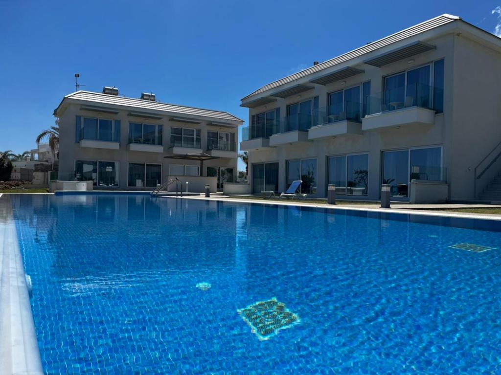 una gran piscina azul junto a un edificio en Ocean Suites Luxury Apartments, en Protaras