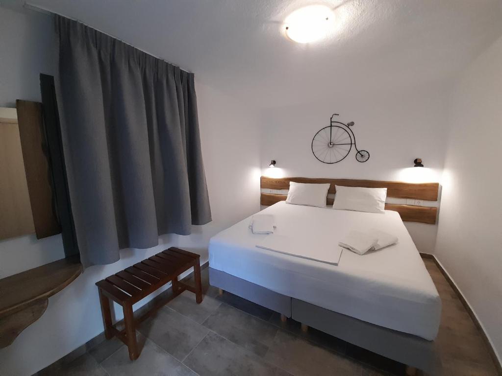 1 dormitorio con cama blanca y banco en Aegean View Mikro Pelion, en Mikro