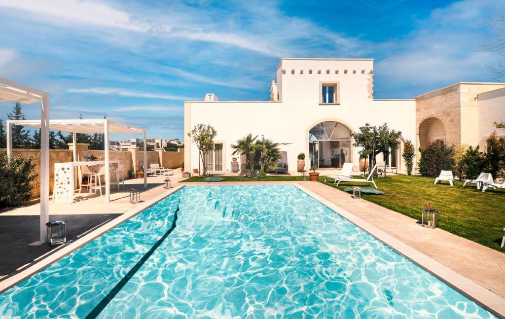 a villa with a swimming pool in front of a house at Dimora Oru in Lecce