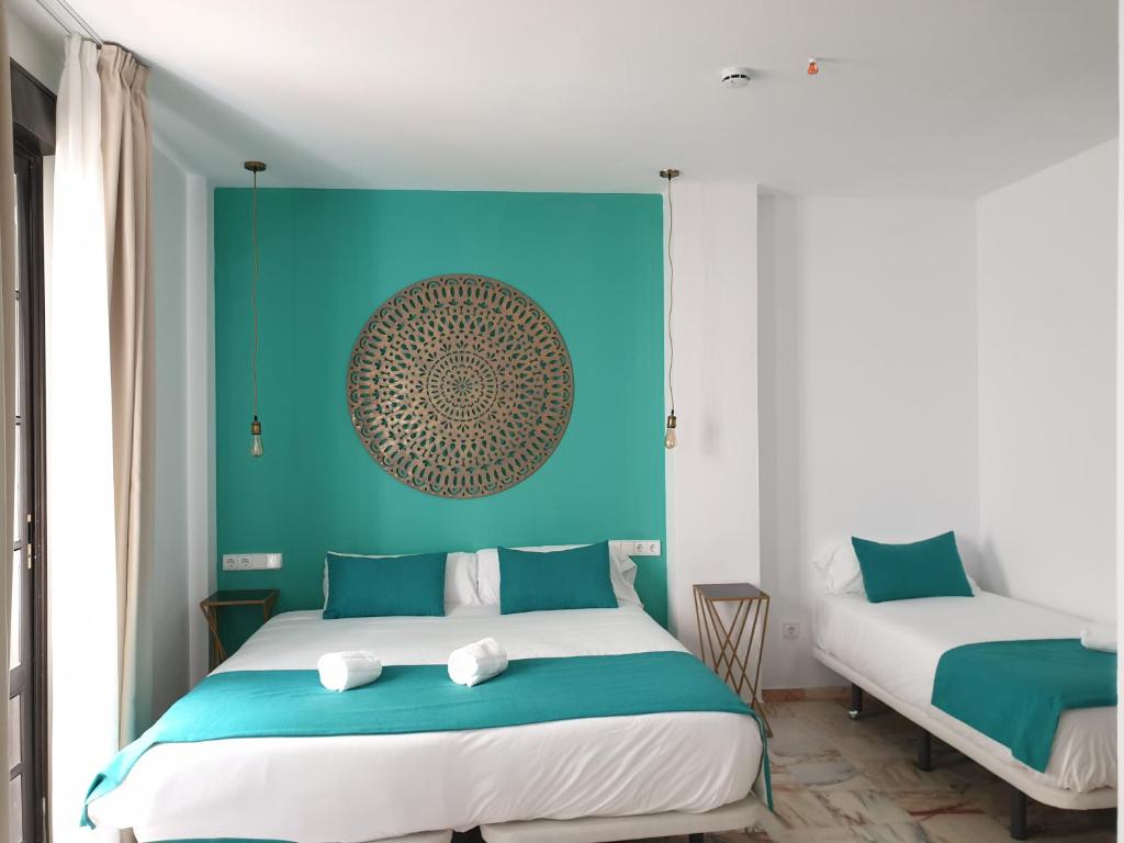 sypialnia z łóżkiem i niebieską ścianą w obiekcie Hotel y Apartamentos Doña Lola w Sewilli