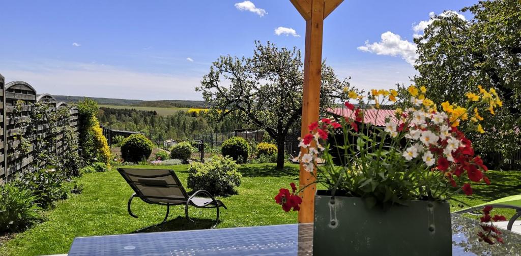 un patio con una silla y flores en Ferienhaus Diana im Harz, en Pansfelde