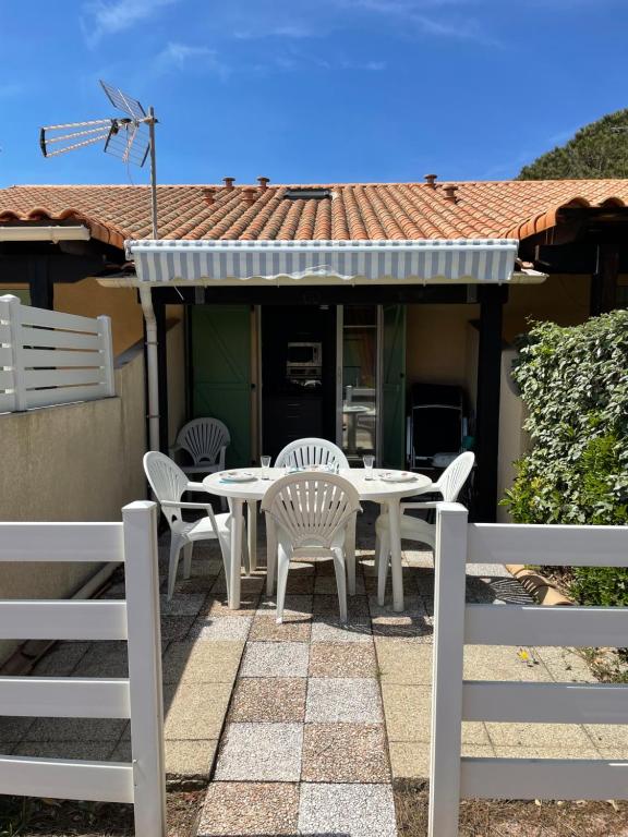 une terrasse avec une table et des chaises dans une maison dans l'établissement Pavillon idéal famille avec piscine 800m des plages 4LHA60, à Saint Pierre La Mer
