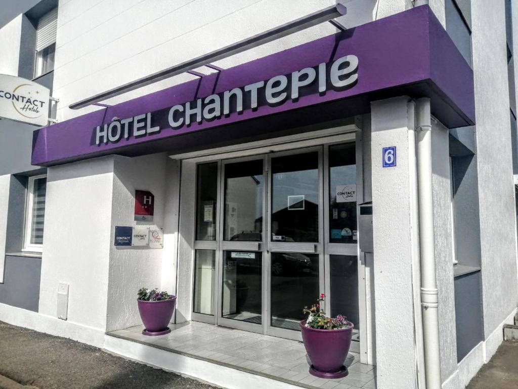 ジュエ・レ・トゥールにあるHôtel Chantepieの鉢植えの植物が2本前に並ぶホテルの入り口