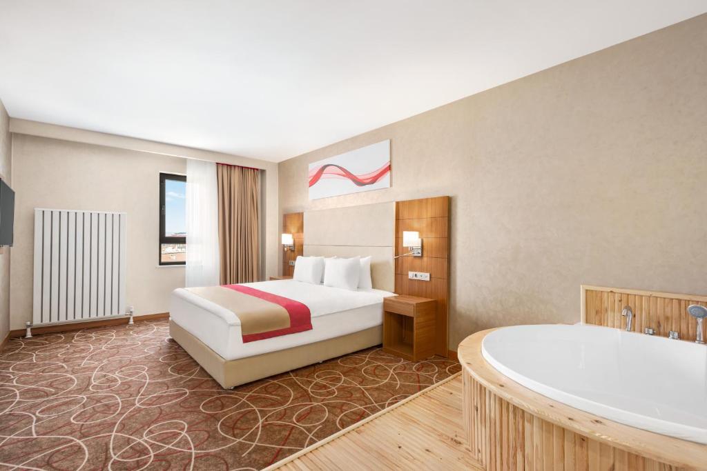 A bed or beds in a room at Ramada By Wyndham Elbistan