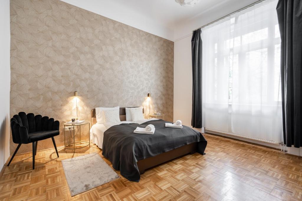 a bedroom with a bed and a large window at BpR Swan apartment near the Buda Castle in Budapest